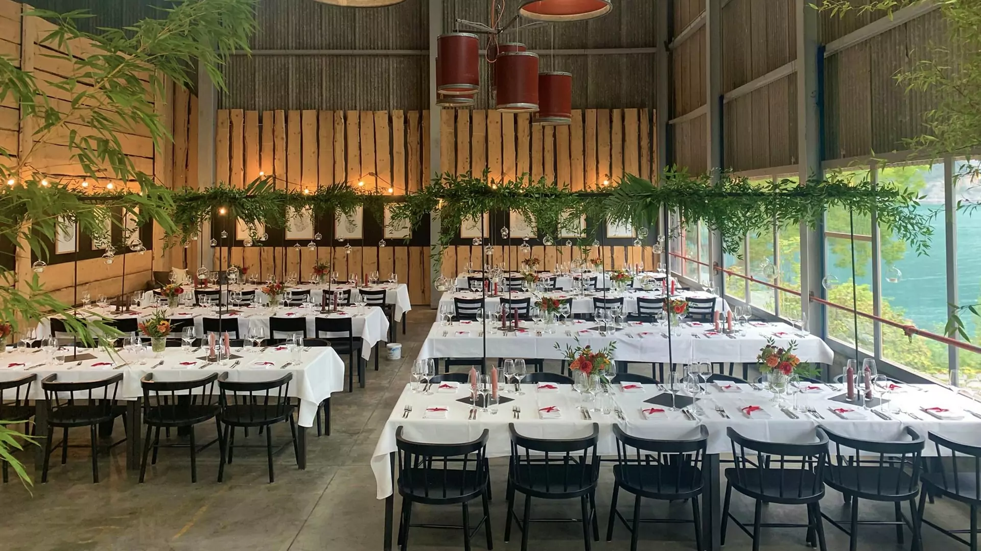 Das Holzlager in der Sagibeiz eingerichtet mit weiss gedeckten Tischen für eine Hochzeit.